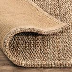 Backside of rug folded to show woven construction and fabric backing detail