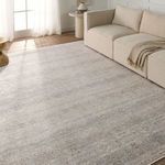 Rug placed in living room under beige sectional sofa with sunlight on the surface