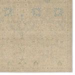 Detailed view of rug corner showing faded floral motifs and subtle geometric border