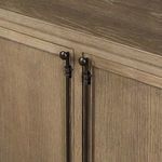 Detailed view of aged bronze locking hardware on double doors of sideboard