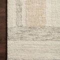 Corner of Milo Slate Olive rug on dark wood floor highlighting edge binding and wool texture