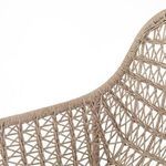 Tight detail of woven wicker seat transitioning into metal leg frame