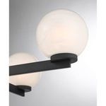 close-up of frosted glass orb with swirling strie texture atop matte black arm with knurled ring