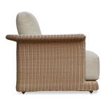 Side profile showing Meredith chair’s woven wicker frame and thick cushions