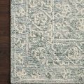 Corner view of Cecelia Ocean rug laid on dark wood floor highlighting intricate plush pattern texture