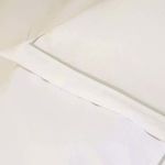 Close-up of sateen fabric texture and subtle piping detail on duvet cover edge