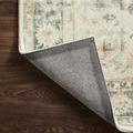 Rosette rug corner flipped to reveal durable woven non-slip backing in contrasting gray fabric