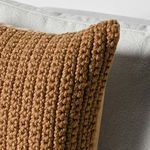 Close-up showing textured knit stitches and pillow corner detail on sofa