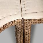Detail showing tufted cream cushions on the sectional bench with rattan frames
