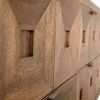 Close-up of faceted pyramidal wood drawer fronts and brushed brass pulls on Musashi Walnut console