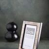 Resin Horn Picture Frame placed on textured surface with blurred black decorative object in background