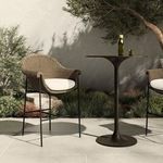 Outdoor bar stool paired with matching stool and black pedestal table on large gray tiles