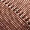 Close-up of woven earth red fabric with cream stitched textured stripe detailing across pillow center