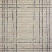 Beige area rug with an abstract modern linear plaid pattern in earth tones and distressed texture with fringed edges.