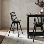 Rear angled view of stool showing full backrest and sturdy leg footprint