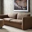 Styled room context showing full rug under sofa with subtle natural wood grain flooring