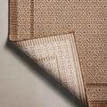 Rug corner folded over displaying the textured woven back and dense weave structure