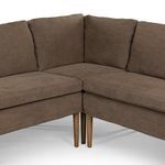 Close-up of banquette inner corner joint and wooden legs with visible linen cushion texture.