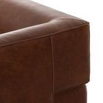 Close-up of rounded arm top corner with leather piping