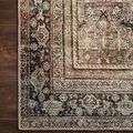 Close-up corner of Layla rug on dark wood floor highlighting distressed texture and faded border details