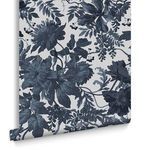 Roll of wallpaper showing floral pattern in blue and off-white, viewed from side angle