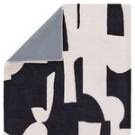 Rug corner lifted to reveal solid gray backing fabric