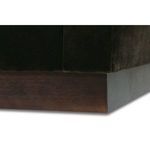 Close-up of wide left armrest top surface with plush dark upholstery