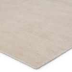 Close-up of soft woven PET yarn texture and rounded edge of cream and light brown rug