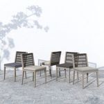 Group of six outdoor dining chairs in different cushion colors on stone tile floor