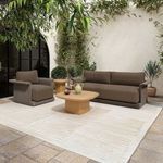 Manon Outdoor Side Table styled outdoors next to woven armchair and sofa on light patterned rug