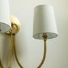 Frontal close-up highlighting the brushed brass finish and white linen shades