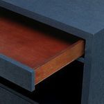 Partially open top drawer showing natural wood interior contrasting with navy blue exterior