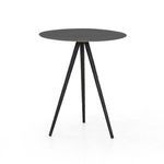 Black tripod end table styled with decorative vase and greenery near vertical window blinds