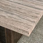 Close-up of tabletop corner showing light stone laminate texture and block leg with vertical ridges