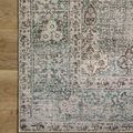 Detail close-up of Jules Emerald rug corner folded back to display non-slip backing on hardwood floor