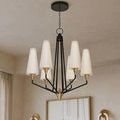 Chandelier showcased in room with soft tan walls and two brass sconces flanking artwork