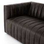 Tight shot of sofa seat and corner arm showcasing smooth leather upholstery and stitching