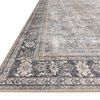 Close-up angled view showing detailed floral border and textured surface of the rug