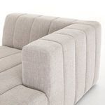 High angle detail of curved vertical channel armrest over cushioned seat of sandstone sectional