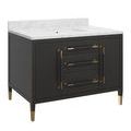 angled view of black vanity with gold ferrule feet and hardware on marble countertop