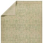 Folded corner of rug revealing backside and fringeless edges