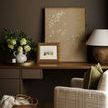 Round galvanized tray with brass rim holding white ceramic vase and decor on wooden desk in cozy styled room