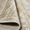 Close-up of rug edge folded to show flexible weave and subtle color variations in ivory and gold