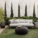 Outdoor lounge setting with Maximus Nesting Side Tables beside light gray cushioned sofa on artificial turf