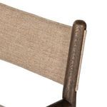 Focused detail of fabric sling-back attached to top wooden dowel on chair