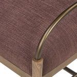 Close-up showing bronze arched arm attaching to wooden leg on plush cushion