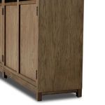 Lower side corner view of cabinet with framed wood doors and solid drifted oak base