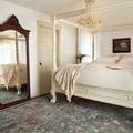 Giada Lagoon rug styled in a bedroom with a white canopy bed and wooden floor