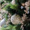 side view of mosaic glass ornament with textured glass pieces nestled on Christmas tree among gold branches