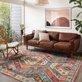 Zion rug styled in modern living room under mid-century leather sofa and rattan armchair